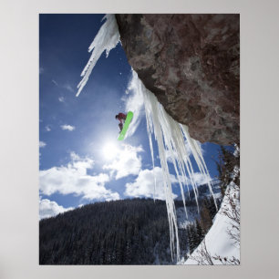 En manlig snowboarder hoppar av ett isvattenfall poster