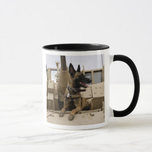 En militär funktionsduglig hund sitter på en M2A Mugg
