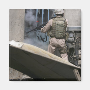 En militärpolis använder en bryta igenom runda magnet