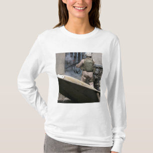 En militärpolis använder en bryta igenom runda tee shirt