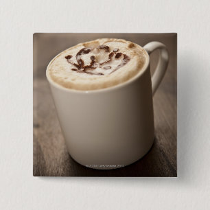 En mugg av Cappuccino-kaffe med smält innehåll Knapp