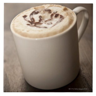 En mugg av Cappuccinokaffe som överträffas med Kakelplatta