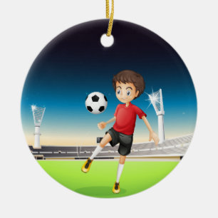 En pojke som leker ensam fotboll julgransprydnad keramik