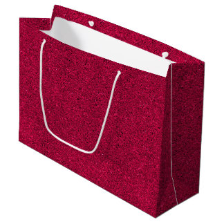 En röd glitterig presentpåse med vita handtag
