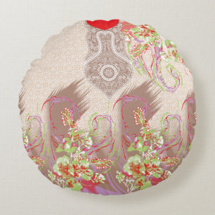 En röd vas med blommor på den rund kudde