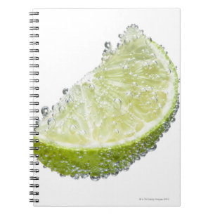 En saftig mogen organisk limefruktkilfrukt doppade anteckningsbok med spiral
