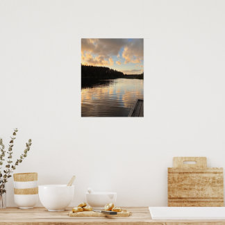 En sjö vid solnedgång som speglar himlen poster