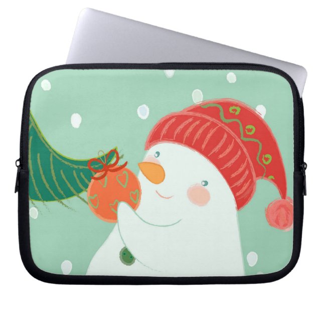 En snögubbe som hänger en prydnad på ett träd laptop sleeve (Framsidan)