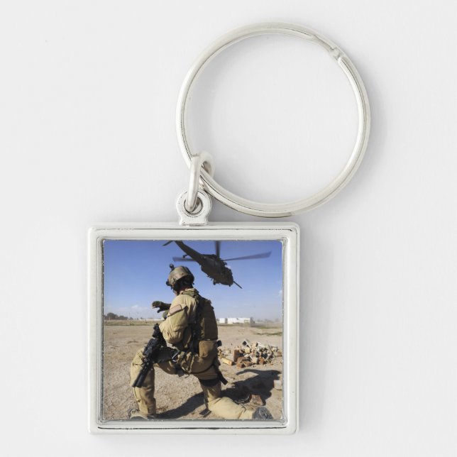 En soldat sköter säkerheten för en HH-60 Fyrkantig Silverfärgad Nyckelring (Framsidan)