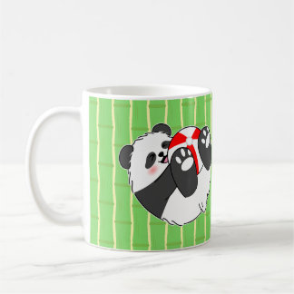 En söt baby panda leker med en boll kaffemugg