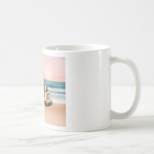 En sötnare randig katt som sitter på stranden vid kaffemugg