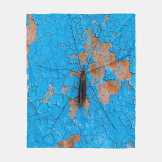 En stor myggorm sitter på en blå gammal krackad wa fleecefilt