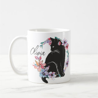 En svart katt omgiven av blommor kaffemugg