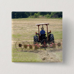 En ung pojke kör en traktor som skördar knapp