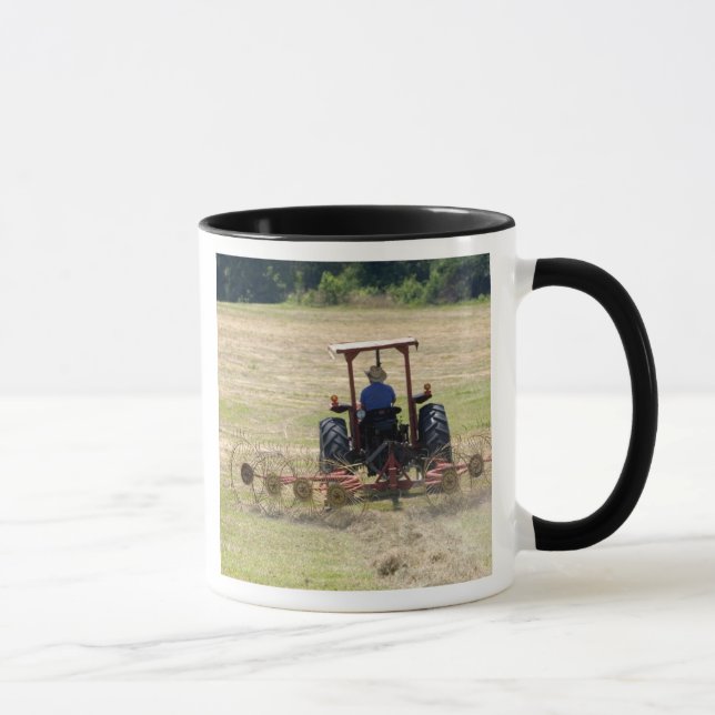 En ung pojke kör en traktor som skördar mugg (Höger)