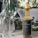 Enkel Elegant Black Bröllop Tack Mini Vinetikett<br><div class="desc">Dessa mini-vin-flaska-etiketter har en utformning som är enkel men ändå elegant med lacy white calligraphy på en svart bakgrund med en ram-gräns. Perfekten läggs till en bröllop-säck eller som en tjänst för gäster, familj och medlemmar av bröllopsfesten. Texten lyder: Tack för firandet! Det finns utrymme för parets namn, bröllop-datum och...</div>