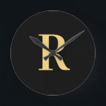 Enkel Monogram Modern Black Guld Rund Klocka<br><div class="desc">Detta är en enkel, modern monogramdesign för personligen. Den här snyggten är i färd med att trendera svart och guld med snyggt typografi. Det är perfekt för en personlig-gåva eller idealisk som en ny snyggt för dig själv. Lägg bara till det första brev genom att skriva in det i textrutan...</div>