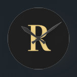 Enkel Monogram Modern Black Guld Rund Klocka<br><div class="desc">Detta är en enkel, modern monogramdesign för personligen. Den här snyggten är i färd med att trendera svart och guld med snyggt typografi. Det är perfekt för en personlig-gåva eller idealisk som en ny snyggt för dig själv. Lägg bara till det första brev genom att skriva in det i textrutan...</div>