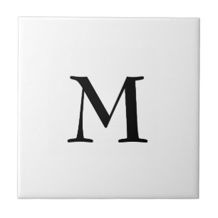 Enkelt svart monogram på vitt kakelplatta