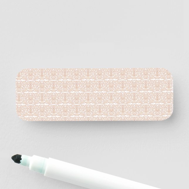 ett beige och vitt checkat mönster på vit bas namnbricka (På plats)