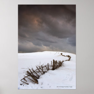 Ett brutet stängsel vid ett Snö täckt Fält Poster