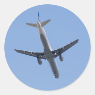 Ett flygplan i bakgrunden blå himmel runt klistermärke