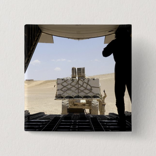 Ett gaffeltruft lastar last på C-130 Hercules Knapp (Framsida)