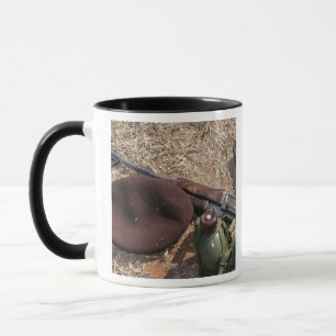Ett gevär, militär täcker och kantinen mugg