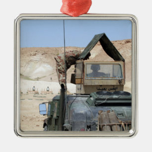 Ett mer soldiier instruerar en irakisk armésoldat julgransprydnad metall