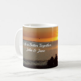 Ett par sittplatser på stranden vid solnedgången i kaffemugg