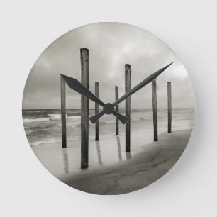 Ett sepiskt tonat skott av gamla strandstolpar rund klocka