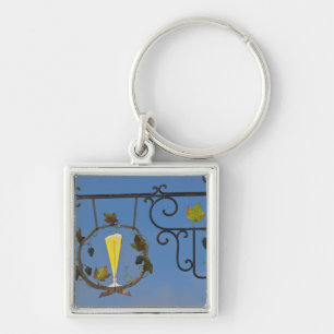 Ett skrivtecken från järn som illustrerar temat fyrkantig silverfärgad nyckelring