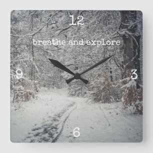Ett snö-täckt väg genom en vinterskog fyrkantig klocka