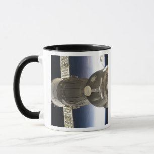Ett Soyuz rymdskepp backdropped av jord Mugg