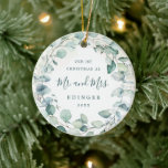 Eucalyptus Greenery Mr. och Photo Newlyed Julgransprydnad Keramik<br><div class="desc">Elegant keramiskt prydnadsämne som innehåller en andedräkt bestående av eukalyptus löv och grönt med ett blått tips med "Vår första jul som Mr och Mrs" tillsammans med ditt efternamn och år mörk grönt över en pastellfärgad tvätta. Baksidan har ditt favoritfoto från bröllop. Denna soliga botaniska ornament ger också en underbar...</div>