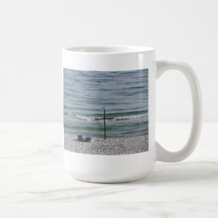 Fågel på träkor vid hav kaffemugg