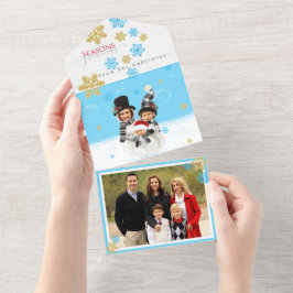Familj med 3 lägger till ansikte till ett snögubbe