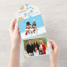 Familj med fyra lägger till ansikte till ett snögu