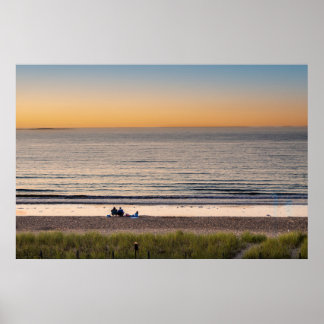Familjen sitta på stranden vid solnedgången poster