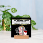 Family Home Movie Theater Anpassningsbar Sign with<br><div class="desc">Den här söta,  prisvärda miniskylten för bordsteatrar är perfekt för hemmabiofilmer. Den har en filmrulle,  popcorn,  soda och en filmmarkeringsram för anpassningsbar på en svart bakgrund. Anpassa enkelt filmmarkeringsramen med namn eller annan text. Du kan enkelt ändra den svarta bakgrunden genom att klicka på "Anpassa den här mallen".</div>