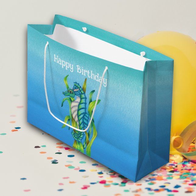 Fantasy Söt Aqua Blue Seahorse Sjögräs Birthday (Fantasy sea dragon with horns in bright aqua blue holding seaweed on blue Birthday gift bag.)