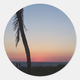 Färgfullt tropiskt solnedfall på en runt klistermärke