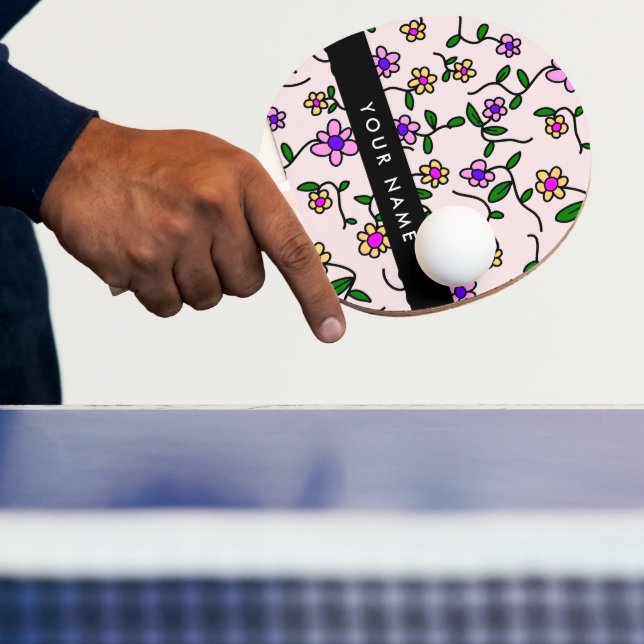 Färgglada blommor, rosa bakgrund, svart pingisracket (Insitu)