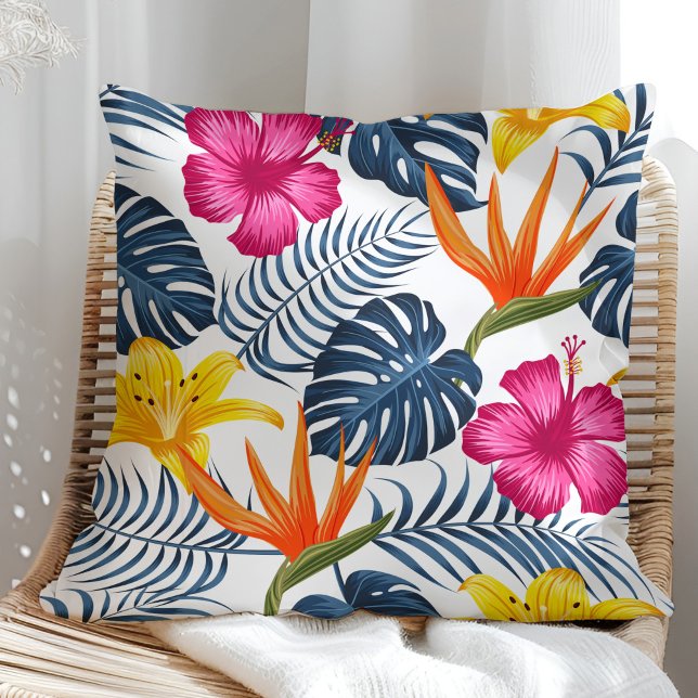 Färgrik tropisk design på en vit kudde (Colorful tropical design on a white pillow in a sunny rattan armchair.)