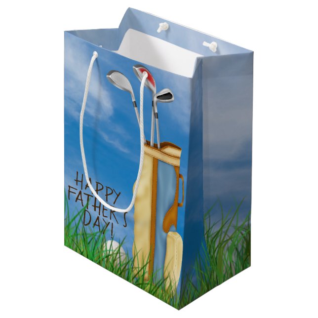 Fars dag-golfpåse och klubbar med boll i gräs (Framsidan Vinklad)