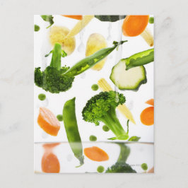 Färska grönsaker med vatten som faller i en skål vykort