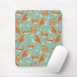 Felaktig Orange Tabby katt som knackar Saker över Musmatta