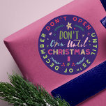 Festiv, Roligt och färgstark Öppna inte jultomten Runt Klistermärke<br><div class="desc">Skydda din Julklapp från dina snikliga peekers med vår roligt, nyfiken och färglös "Öppna inte förrän jul"-klistermärken. Designen har olika roligt och fet typografisk typografi för att skapa en roligt. Ljusa färger av , nyp, gröntar, blues och faux guld accents mot en mörk marin blå bakgrund skapar en fångstdesign för...</div>