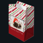 Festive Pug in Red Santa Hat med julljus<br><div class="desc">En presentväska med ett foto av en söt pug-valp som sover medan du bar en röd tomhatt. God jul är skrivet på hattens band i ett handskrivet trendig. Ett svart, grymt gräns med färglöst helgdag omger ram på detta beundransvärda foto. Bakgrunden är ett mönster som utplånats av candy cane i...</div>
