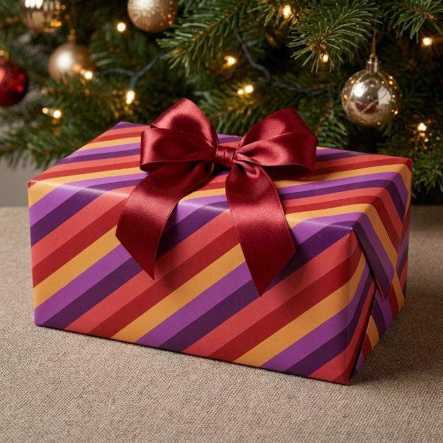 Fet retro röd lila guld randigt inslagspapper presentpapper (Bold Retro Red Purple Gold Stripes Wrapping Paper wrapped around a present under a Christmas tree.)
